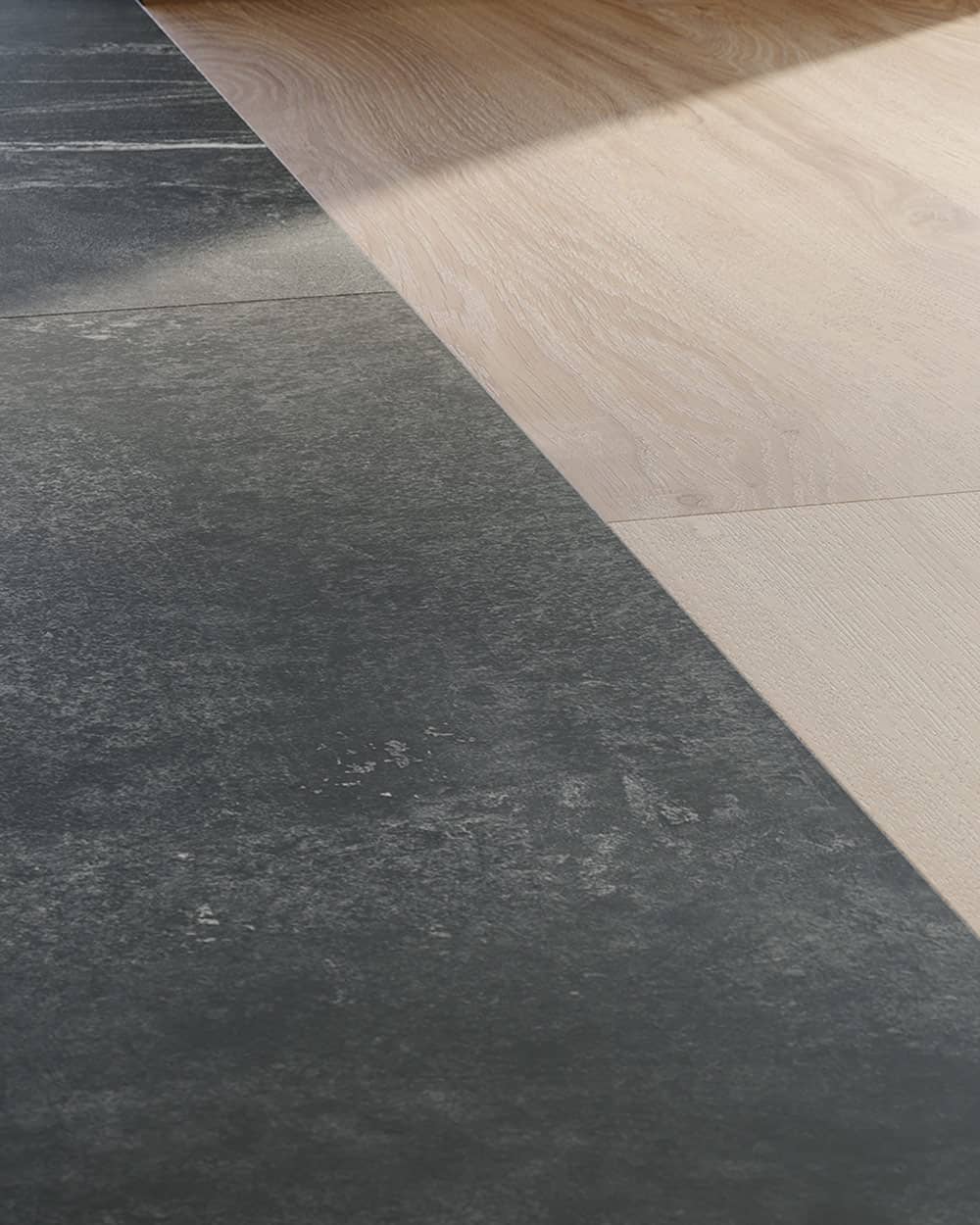 Vue de détail d'une transition diagonale en douceur entre des dalles vinyles effet pierre grise et des planches vinyles effet bois de chêne.
